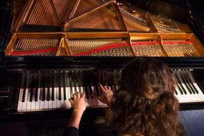 Female Student Playing Piano in Concert